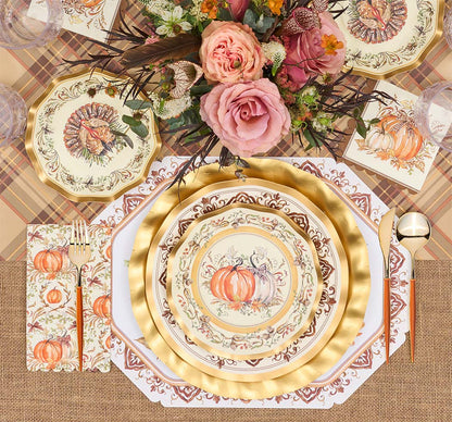 A fall-themed table setting features the Turkey & Gourds Table Setting Bundle by Sophistiplate LLC, including designer disposable plates adorned with turkey and gourd motifs, gold cutlery, plaid and burlap placemats, and a floral centerpiece with pink roses and autumnal blooms. The distinctive turkey design appears on both the top plate and matching napkin.